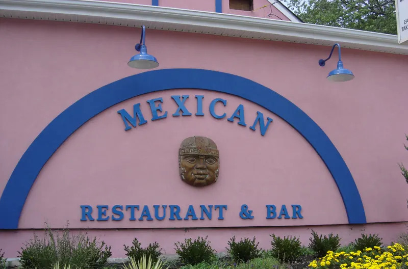 The matching blue arch sign reading Mexican Restaurant and Bar on the pink wall