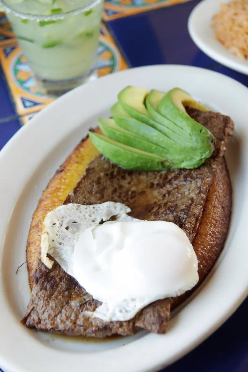Bistec a la Criolla: grilled steak on a sweet plantain with an egg over easy and avocado