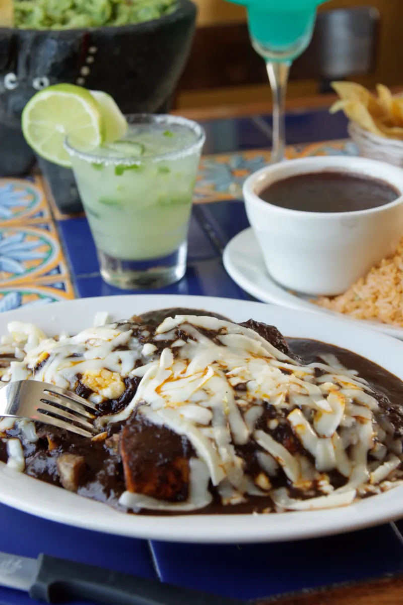 Enchiladas de mole poblano with a fresh margarita in front